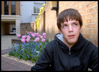 Teenager sat by a flower bed
